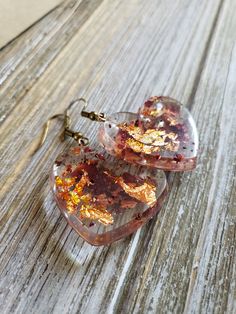 Beautiful natural rose petals in heart resin earrings. Hues of amber red paired with fiery copper flakes make these natural earrings boldly colorful. Bronze metal earrings with handmade resin heart pendants with real dried rose petals ♥ Be sure to check out the ORANGE EARRINGS section at EarringsbyLCreations for all beautiful orange colored earrings available! https://www.etsy.com/shop/EarringsByLCreations?section_id=28420987 Made with quality materials and always nickel and lead free metals. Na Resin Heart Earrings For Gifts, Gold Heart-shaped Flower Earrings, Valentine's Day Heart-shaped Flower Earrings For Pierced Ears, Handmade Heart-shaped Flower Earrings For Gift, Heart-shaped Gold Flower Earrings For Valentine's Day, Gold Heart-shaped Flower Earrings For Valentine's Day, Valentine's Day Gold Heart Flower Earrings, Valentine's Day Heart-shaped Gold Flower Earrings, Pink Heart-shaped Flower Earrings For Gift