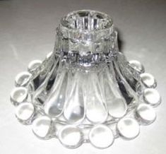 a clear glass candle holder sitting on top of a table