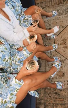 three women sitting on a couch holding wine glasses