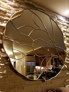 a round mirror hanging on the side of a stone wall