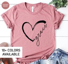 "This Grace shirt is the perfect birthday gift for women! All of our shirts are made with the highest quality materials and are super soft and cozy! 💚 HOW TO ORDER 💚 1. Check our photos for sizing and color options. 📏 2. Choose your quantity. Feel free to add as many shirts as you wish! ✨ 3. Select your size and color from the drop-down menus. ✨ 4. Click \"ADD TO CART\" to add the shirt to your virtual cart. 🛒 5. Click \"PROCEED TO CHECKOUT\" to purchase your shirt. 🛒 6. Your shirt is now o Cute Relaxed Fit T-shirt As Gift, Cute T-shirt With Heart Graphic For Gift, Cute T-shirt With Heart Graphic As Gift, Cute Heart Graphic T-shirt For Gift, Cute Heart Graphic T-shirt As Gift, Graphic Tee Shirt For Mother's Day Gift, Mother's Day Graphic Tee Tops As Gift, Valentine's Day Letter Print T-shirt Gift, Relaxed Fit Tops With Custom Text For Gifts