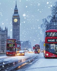 two red double decker buses driving down a snowy street