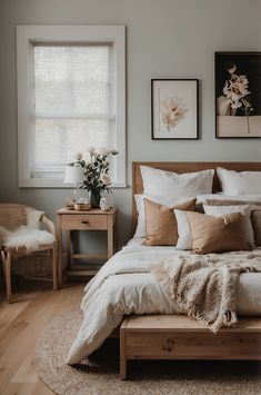 a bed sitting in a bedroom next to a window with white curtains and pillows on top of it