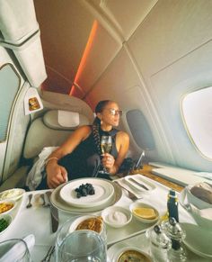 a woman sitting in an airplane with food on the table