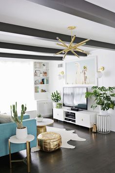 a living room filled with furniture and a flat screen tv on top of a wooden floor