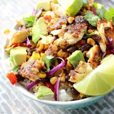 a colorful salad with chicken, avocado and cilantro in a bowl