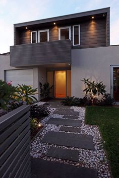 a modern house with stone steps leading up to the front door and side yard area