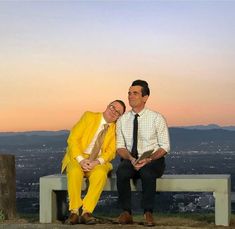 two men in yellow suits sitting on a bench