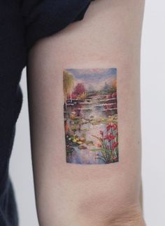 a woman's arm with a small painting on the back of her left arm