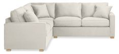 a white sectional couch with pillows on it