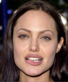 a close up of a woman with long brown hair and green eyes wearing a tiara