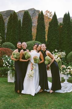 a group of women standing next to each other on top of a lush green field