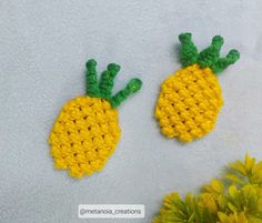 two crocheted pineapples sitting next to each other on a white surface