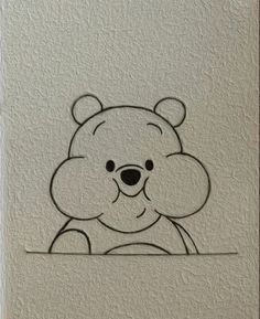 a drawing of a teddy bear on a white wall with the outline of it's face