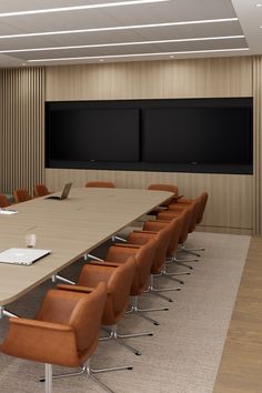 an empty conference room with chairs and a flat screen tv on the wall behind it