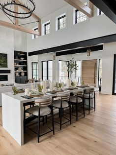 a large dining room table with chairs and plates on it in front of an open floor plan