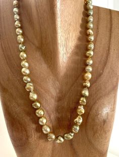 True Baroque shape 9-11.8mm Golden South Sea Cultured Pearl Strand Necklace, 23.5" matinee length. Baroque shaped cultured pearls are actually fairly rare to come by. Many dealers often use the word baroque instead of semi-baroque, which still hold a symmetrical structure to the pearl. A true baroque pearl can be compared to the shape of a potato. They make up usually less than one percent of the total harvest and command a higher price than the semi baroque which can amount to 20 to 30% of a harvest. Demand from connoisseurs for this type of pearl is high. Holding these pearls in your hand is like holding gold nuggets! The color is so vibrant! The color and luster for this necklace are very nice with an overall golden color. Some of the baroque cultured pearls can show a dual color, like Gold Pearl Necklace Gift, Formal Gold Hand-strung Necklaces, High Luster Baroque Pearl Necklace For Formal Occasions, Classic Gold Hand-strung Necklace, Gold Hand-strung Pearl Necklace For Gift, Gold Pear-shaped Single Strand Pearl Necklace, High Luster Yellow Gold Pearl Necklace With Round Beads, Luxury Hand-strung Gold Necklace, Luxury Gold Hand-strung Necklace