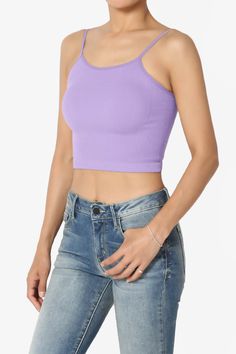 a woman wearing a purple crop top and jeans