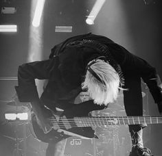 a man with white hair playing bass guitar