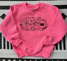 Hey all you Swifties -- a design covering all of her eras on one sweatshirt! This safety pink sweatshirt is available in matching youth and adult sizes. See other listings for shirt options. All items are printed in-house, made-to-order. Pink Sweatshirt, A Design, Cover Design, Adult Outfits, Sweatshirts, Pink, Clothes, Design