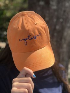 Hats Shown: Shown in Tangerine with 1254 Cobalt Blue true Navy with orange If you choose CUSTOM as the Hat OR Thread color- Please let a note at checkout with the hat and thread color in the Note Section at checkout. Without this information your order will be delayed. Like this style of lettering, but want different text?: https://www.etsy.com/listing/513660627/custom-cap-handwriting-script-baseball?ga_search_query=custom%2Bcap&ref=shop_items_search_7&crt=1 Add text to the back of your Casual Orange Hat With Embroidered Logo, Orange Cotton Hat With Curved Brim, Orange Cotton Baseball Cap, Casual Orange Short Brim Hats, Orange One Size Fits Most Cap, Orange Cap, One Size Fits Most, Orange Adjustable Hat With Embroidered Logo, Orange Adjustable Curved Brim Baseball Cap, Orange Adjustable Baseball Cap With Curved Brim