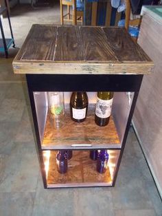 two bottles of wine are sitting in a glass case on the floor next to each other