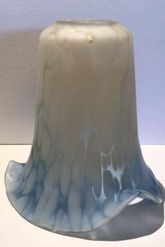 a white and blue vase sitting on top of a table