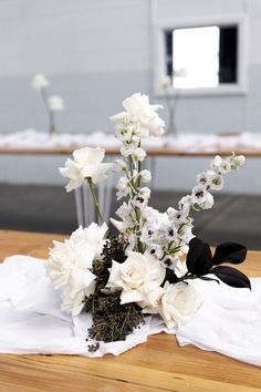 a bouquet of white flowers sitting on top of a wooden table