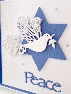 a close up of a greeting card with a dove and star on the side, which reads peace