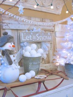 there is a snowman on top of a sleigh next to a christmas tree