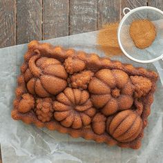 a cake sitting on top of a piece of wax paper next to a strainer