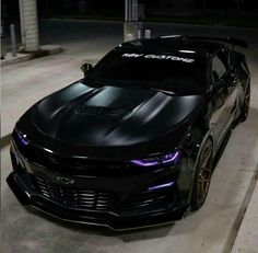 the chevrolet camaro is painted black and has purple lights on it's hood