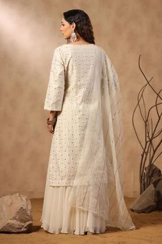 White silk kurta with floral jaal pattern embroidery. Comes with sharara and embroidered dupatta.
Components: 3
Pattern: Embroidered
Type Of Work: Floral Jaal, Sequins, Pearls, Cutdana
Neckline: U Neck
Sleeve Type: Three Quarter
Fabric: Kurta: Silk, Sharara: Georgette, Dupatta: Organza
Color: White
Other Details: 
Attached lining
Approximate product weight: 0.5-1 kg
Occasion: Sangeet - Aza Fashions Silk Sharara, Kurta Sharara Set, Kurta Sharara, Georgette Dupatta, Types Of Work, Silk Kurta, Embroidered Dupatta, Sharara Set, Pattern Embroidery