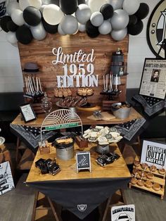 the dessert table is set up with balloons and other items for an event or celebration