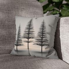 a pillow with trees on it sitting on a couch