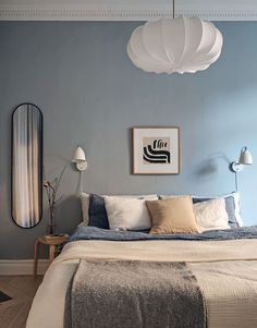 a bedroom with blue walls and white bedding