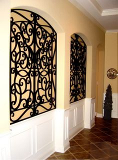 an entry way with two decorative iron screens on the wall