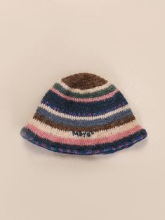 a multicolored knitted hat is displayed on a white surface, with the word natt written across it