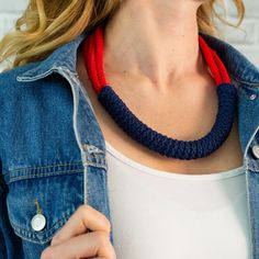 a woman wearing a blue and red necklace with two white buttons on the clasps