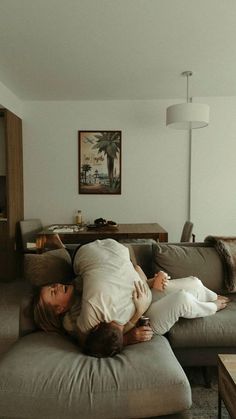 a woman laying on top of a couch in a living room