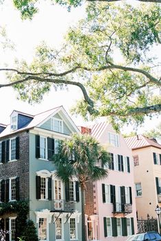 a row of houses with trees in front of them and cars parked on the street