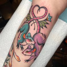 a colorful tattoo on the arm of a woman with an animal and heart in it