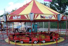 a red and yellow carnival ride sitting on top of a parking lot