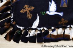 a close up of a black blanket with white birds and snowflakes on it