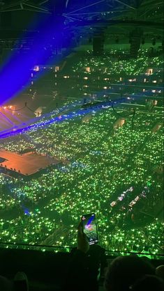 an aerial view of a stadium at night with lights on and people sitting in the stands