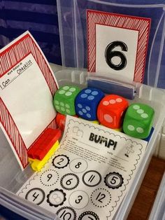 a plastic container filled with lots of dice and numbers