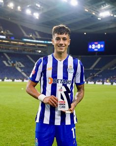 a man holding a trophy on top of a soccer field