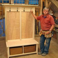 a man standing next to a wooden bench with two baskets on it's back