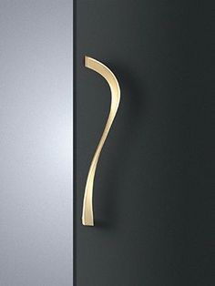 a door handle on the side of a black door with a gold curved design in front of it