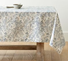 a table with a blue and white floral design on it, next to a wooden bench